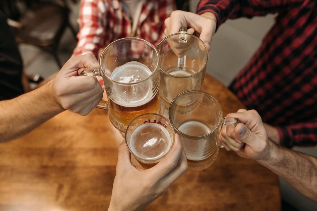 Ein Glas Bier neben Sportausrüstung als Symbol für Alkohol und Training