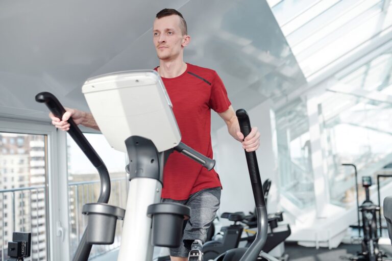 Mann auf einem Crosstrainer (Ellipsentrainer) beim gelenkschonenden Ausdauertraining im Studio