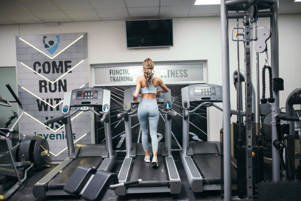 Frau beim intensiven Lauftraining auf dem Laufband im Fitnessstudio