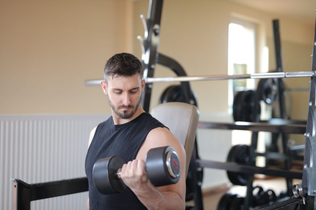 Mann mittleren Alters trainiert mit Kurzhanteln im Fitnessstudio