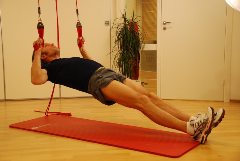 Mann trainiert seinen Rücken gelenkschonend mit einem Schlingentrainer (Inverted Row)