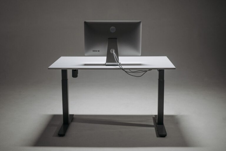 Höhenverstellbarer Schreibtisch in Stehposition mit Monitor und Kabelführung