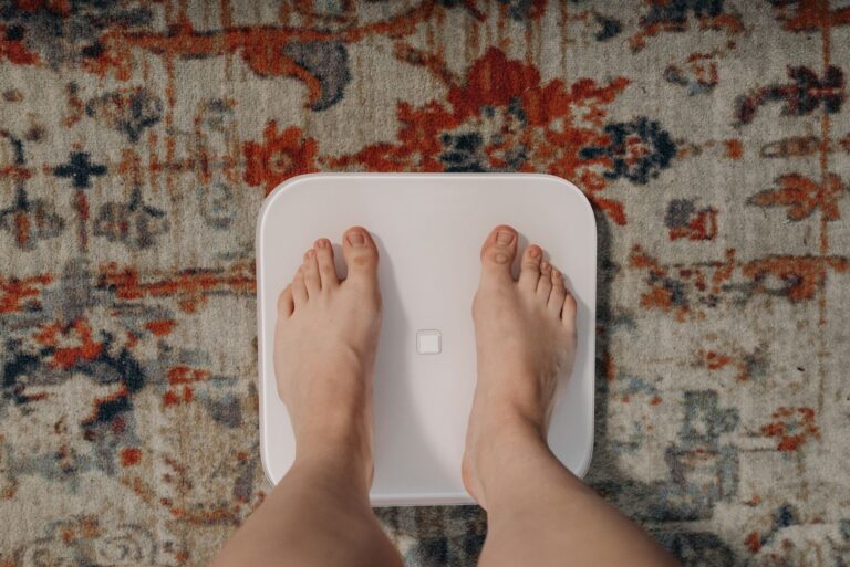 Barfuß auf einer weißen digitalen Körperanalysewaage mit Fußsensoren, Aufsicht