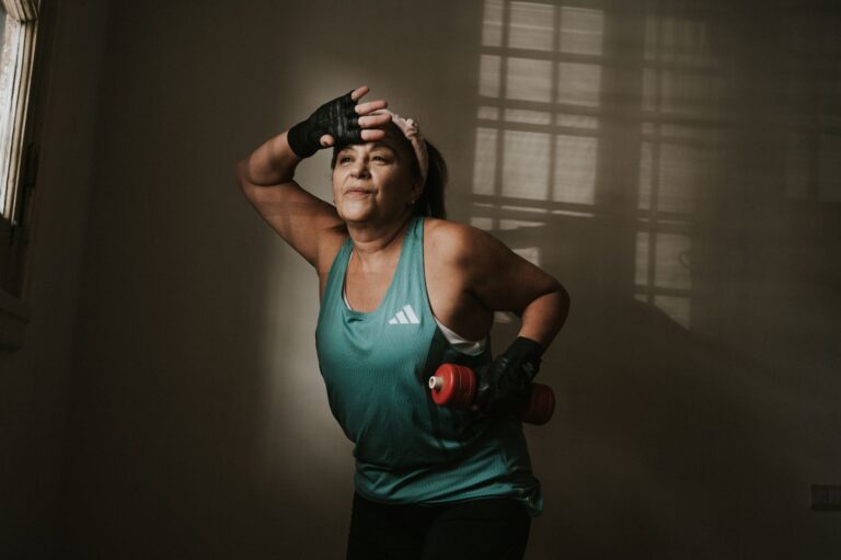 Frau in der Lebensmitte nach dem Krafttraining mit Kurzhantel zu Hause