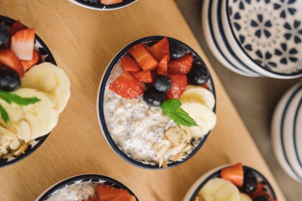 Schale Haferflocken mit Erdbeeren, Heidelbeeren und Banane von oben – Haferflocken und Cholesterin