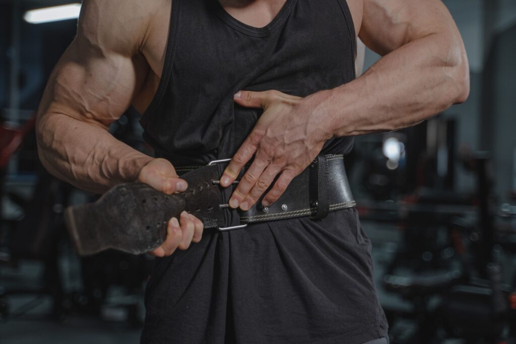Mann legt im Fitnessstudio einen ledernen Gewichthebergürtel an