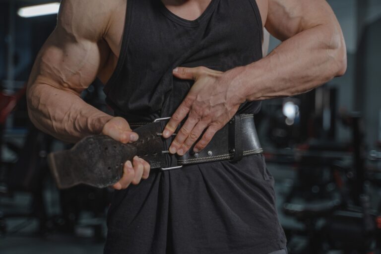 Mann legt im Fitnessstudio einen ledernen Gewichthebergürtel an