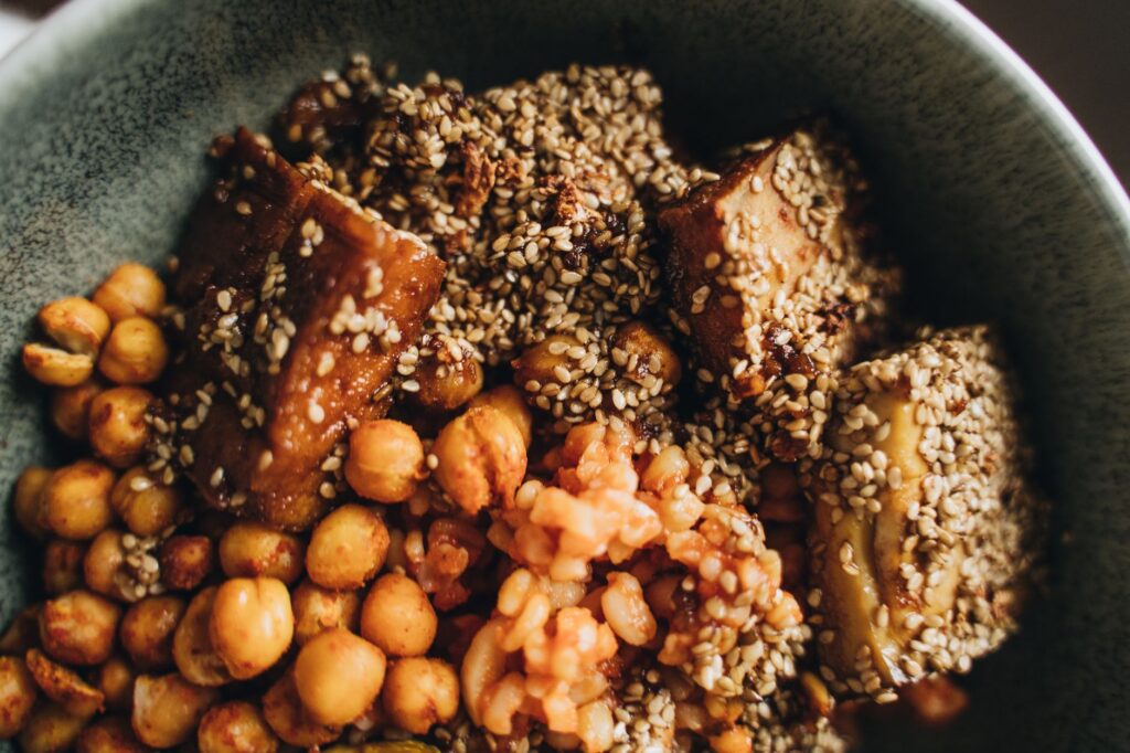 Schüssel mit gebratenem Tofu, gerösteten Kichererbsen und Sesam als pflanzliche Proteinquelle